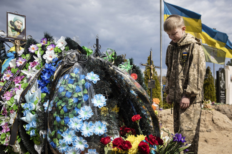 Десетгодишният Савелий плаче на гроба на баща си, загинал при защитата на Ирпин като член на силите за териториална отбрана, в Ирпин, Украйна, 01 май 2022 г. Снимка:  EPA/MIKHAIL PALINCHAK  