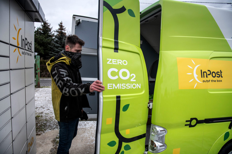 Куриер взима пратка от електрически микробус на фирмата InPost SA в Озаров. Полша. Снимка: Bloomberg L.P.
