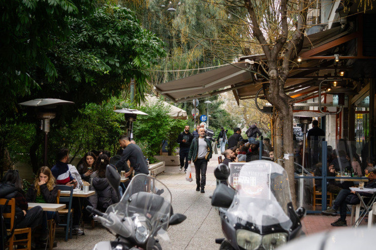 Клиенти на външни маси на ресторант в квартал "Кукаки" в Атина. Снимка: Ioana Epure/Bloomberg