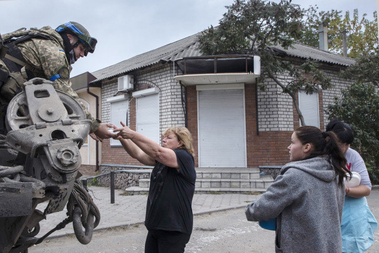 Жени носят топла храна на войниците от украинската армия, която току-що си е върнала контрола над града от руските сили на 11 септември 2022 г. в Изюм. Снимка: Laurent Van der Stockt for Le Monde/Getty Images