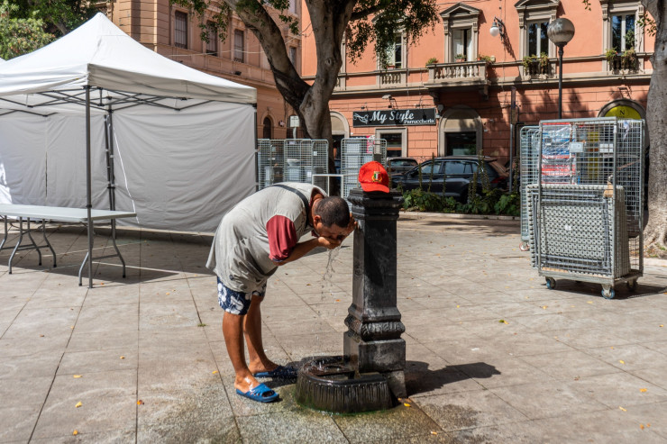 Мъж се охлажда на обществена чешма в Каляри, Италия. Снимка: Francesca Volpi/Bloomberg