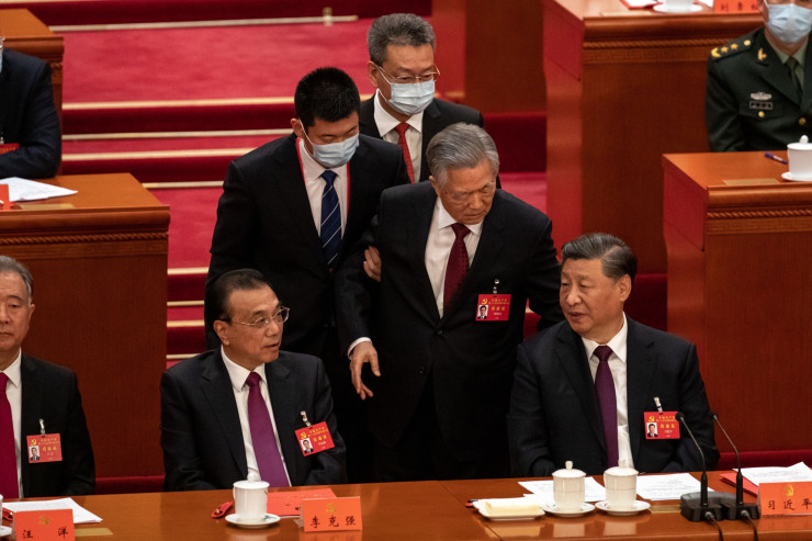 Бившият президент Ху Дзинтао (в средата) говори със Си Дзинпин (вдясно), преди да напусне заключителната сесия на конгреса. Снимка: Bloomberg
