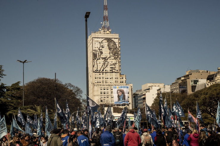 Плакат с лика на вицепрезидента Кристина Фернандес де Киршнер виси под образа на Ева Перон на сградата на Министерството на социалното развитие, докато демонстранти държат знамена по време на митинг в подкрепа на Киршнер след опита за нейното убийство, в Буенос Айрес, Аржентина, в петък, 2 септември 2022 г. Снимка: Anita Pouchard Serra/Bloomberg