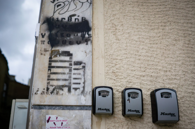 Кутии за ключове до изрисуван надпис "Airbnb навсякъде, съседи никъде" в квартал "Кукаки". Photographer: Ioana Epure/Bloomberg