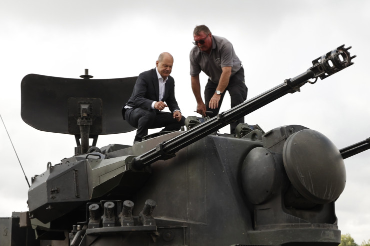 Германският канцлер Олаф Шолц разглежда танк Gepard по време на посещението си в тренировъчна база на производителя на оръжието Krauss-Maffei Wegmann във военния полигон Путлос в Олденбург, Холщайн, Германия, 25 август 2022 г. Германия бе обещала на Украйна доставката на 30 Gepard-а, първият от които пристигна миналия месец. Става дума за самоходни зенитни установки, въоръжени с двойни 35-мм оръдия, които могат да се използват срещу самолети и хеликоптери на височина до 3500 метра. Снимка: EPA/Morris MacMatzen / POOL