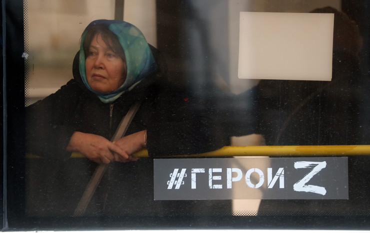 Жена пътува в градски автобус с табела на прозореца с надпис в подкрепа на руската армия, гласящ "#героите Z", в Москва. Снимка: ЕРА